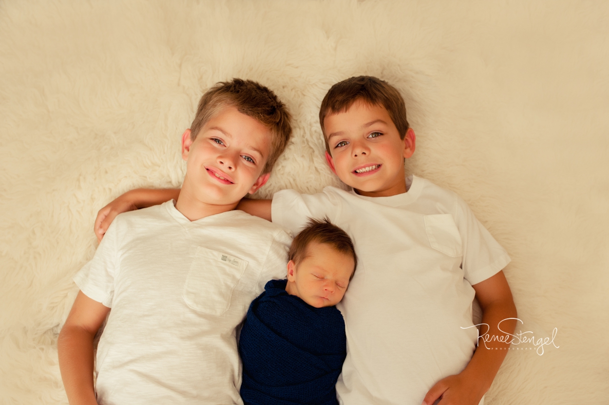Newborn boy in blue with brothers by RENEE STENGEL Photography | Charlotte Portrait and Underwater Photographer