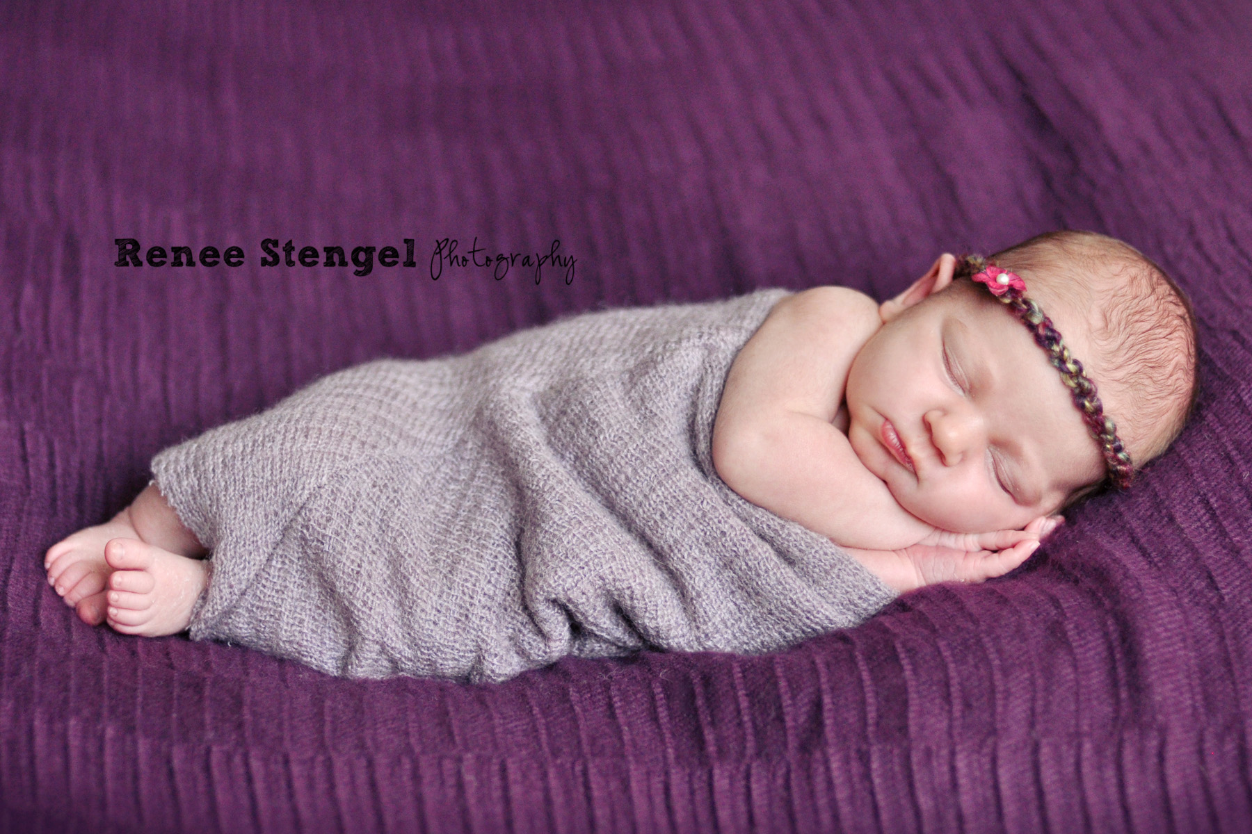 Newborn wrapped in purple 