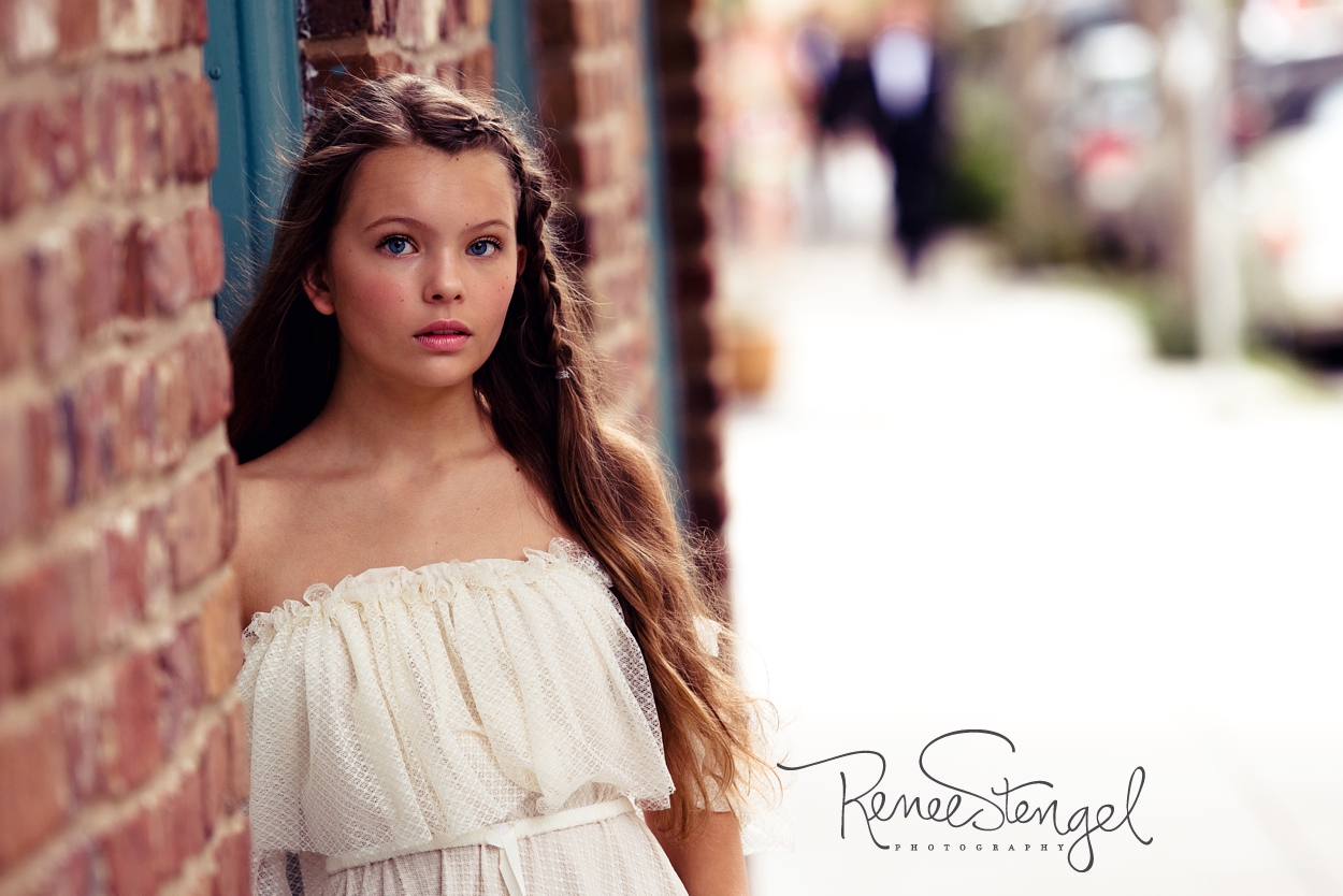 Young girl in Free People dress in Charleston SC next brick wall
