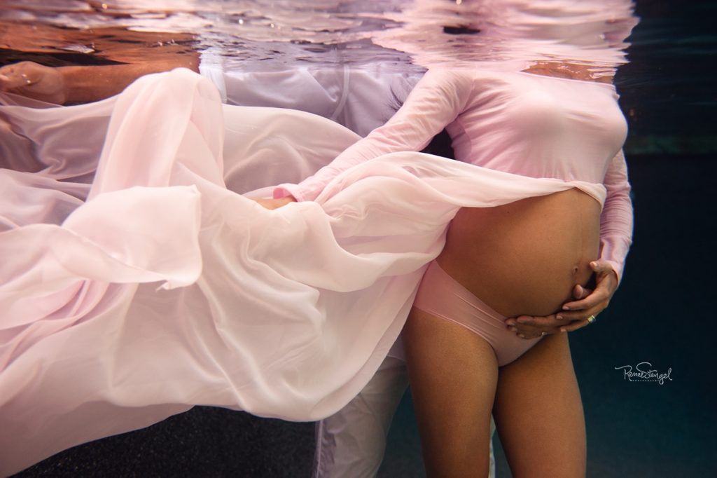 Underwater Maternity Couple in Flowing Pink Dress with Bare Belly