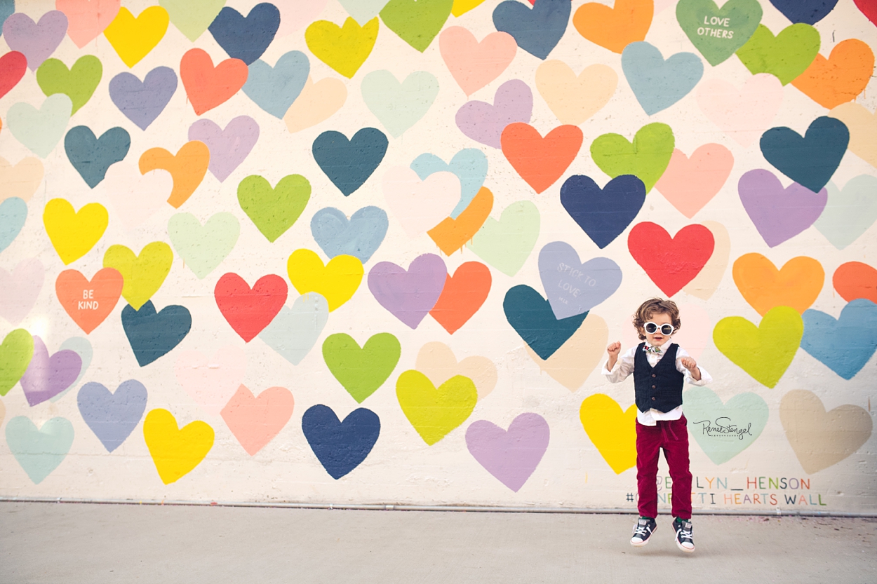 Cool Toddler Jumping for Joy at Charlotte's Confetti Hearts Wall by Evelyn Henson