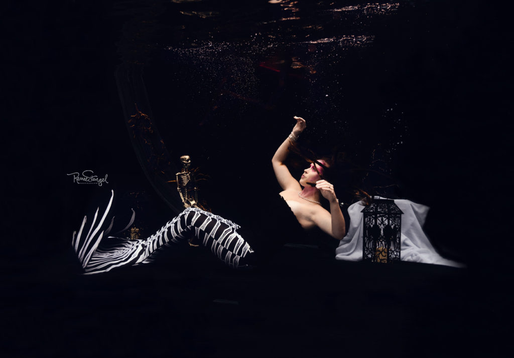 Underwater Skeleton Mermaid sinking against dark black backdrop