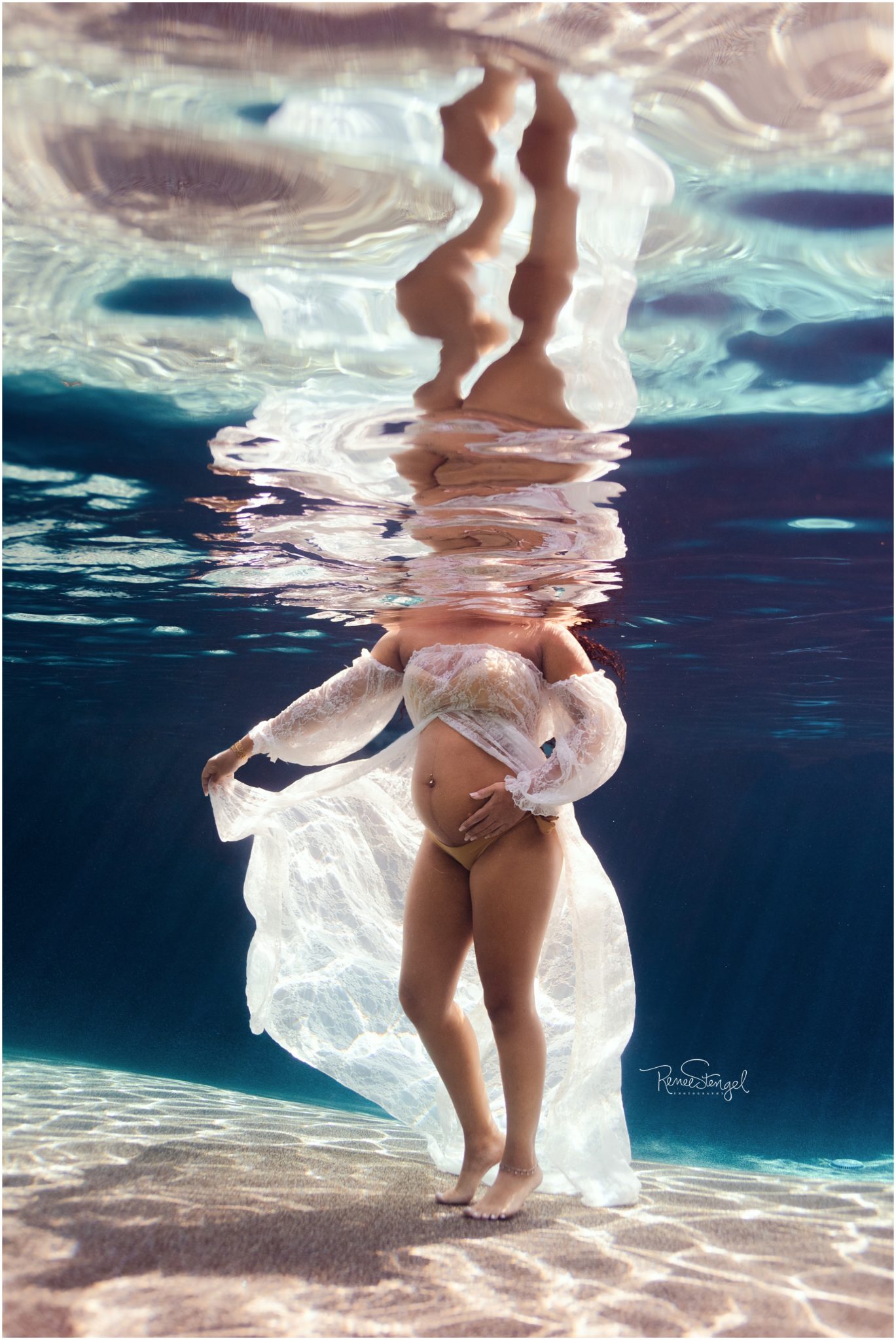 African American Underwater Maternity Session with white lace dress and tropical blue water